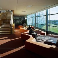 View of seating area in library showing stairs, shelving, seating, copper cladding on facade that extends to interior and students studying, Galway-Mayo Institute of Technology, University, Europe, Ireland, Galway, 2003, Murray O'Laoire. (Photo by View Pictures/Universal Images Group via Getty Images)