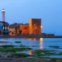 Dawn at Punta Secca Beach with the lighthouse and the watchtowerTorre Scalambri in Santa Croce Camerina Sicily Italy